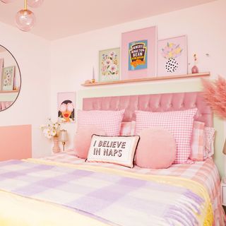 Pale pink bedroom with artwork, cushions and feminine decor