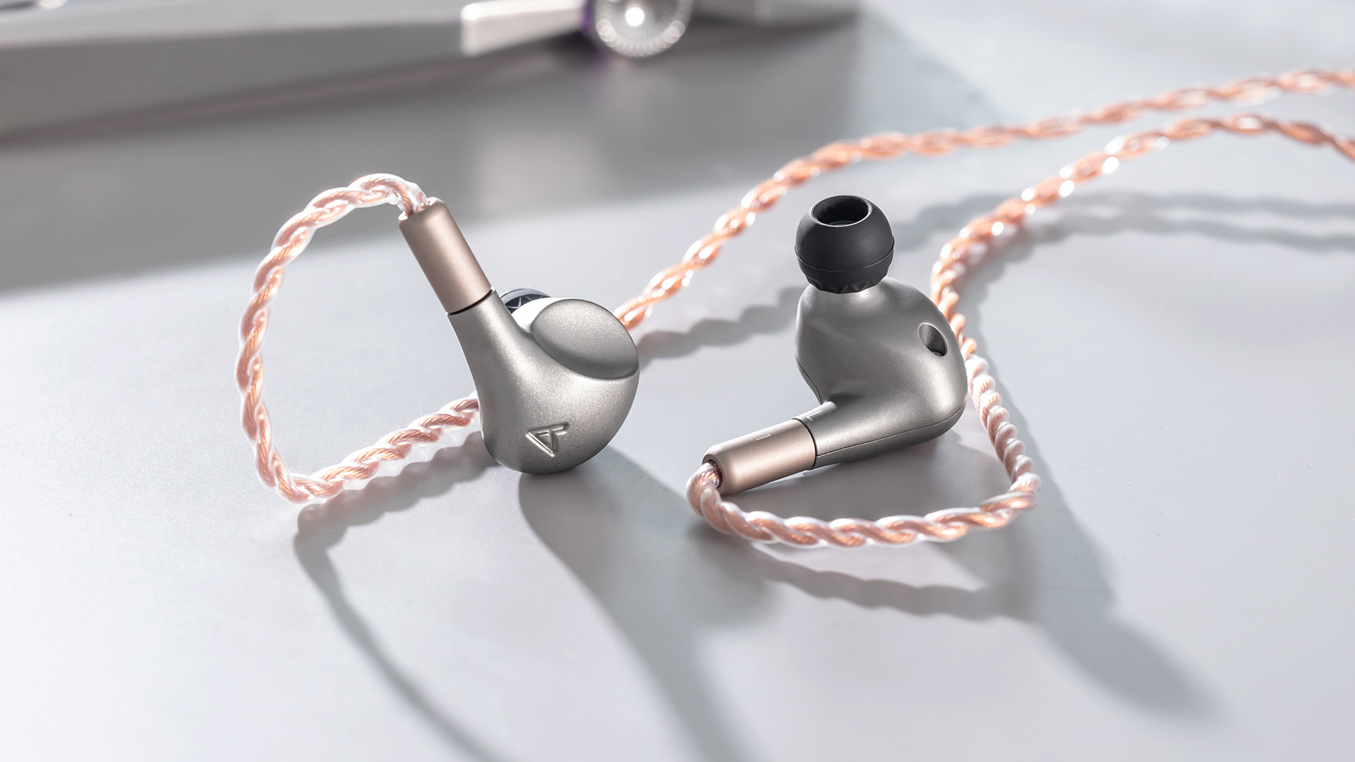 Astell&Kern Luna in-ear monitors on table with media player in background