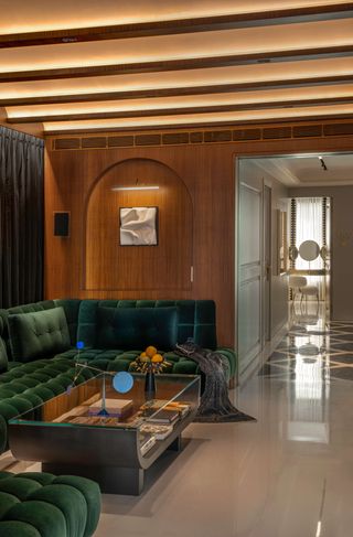 Wood panelled living room with green velvet sofa