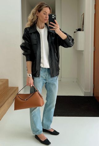 best womens shackets shown on a woman taking a mirror selfie wearing a black jacket over a white t-shirt with jeans and ballet flats