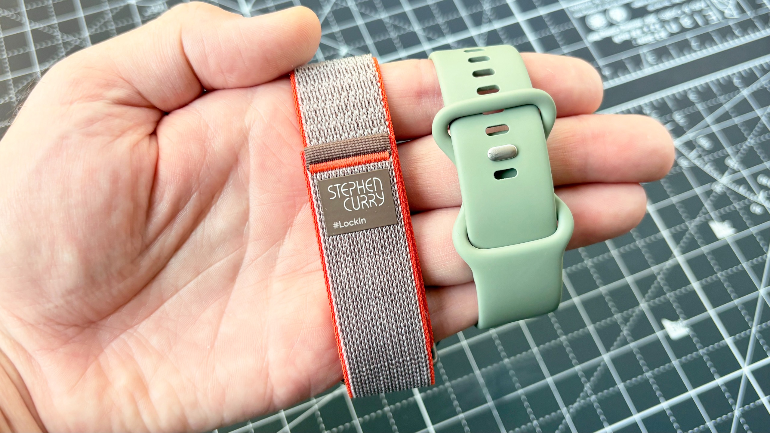 Close-up of the Google Pixel Watch 5 Stephen Curry special edition smartwatch's Velcro strap next to a standard Pixel Watch 5 with a silicone strap