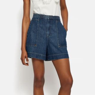 Image of woman in denim shorts and white top