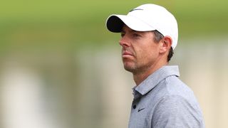 Rory McIlroy wearing a white cap and grey polo shirt looks on during a DP World Tour event