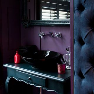 bathroom with black basin and purple wall