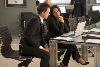 Patrick J. Adams as Mike Ross and Meghan Markle as Rachel Zane in Suits, both wearing suits