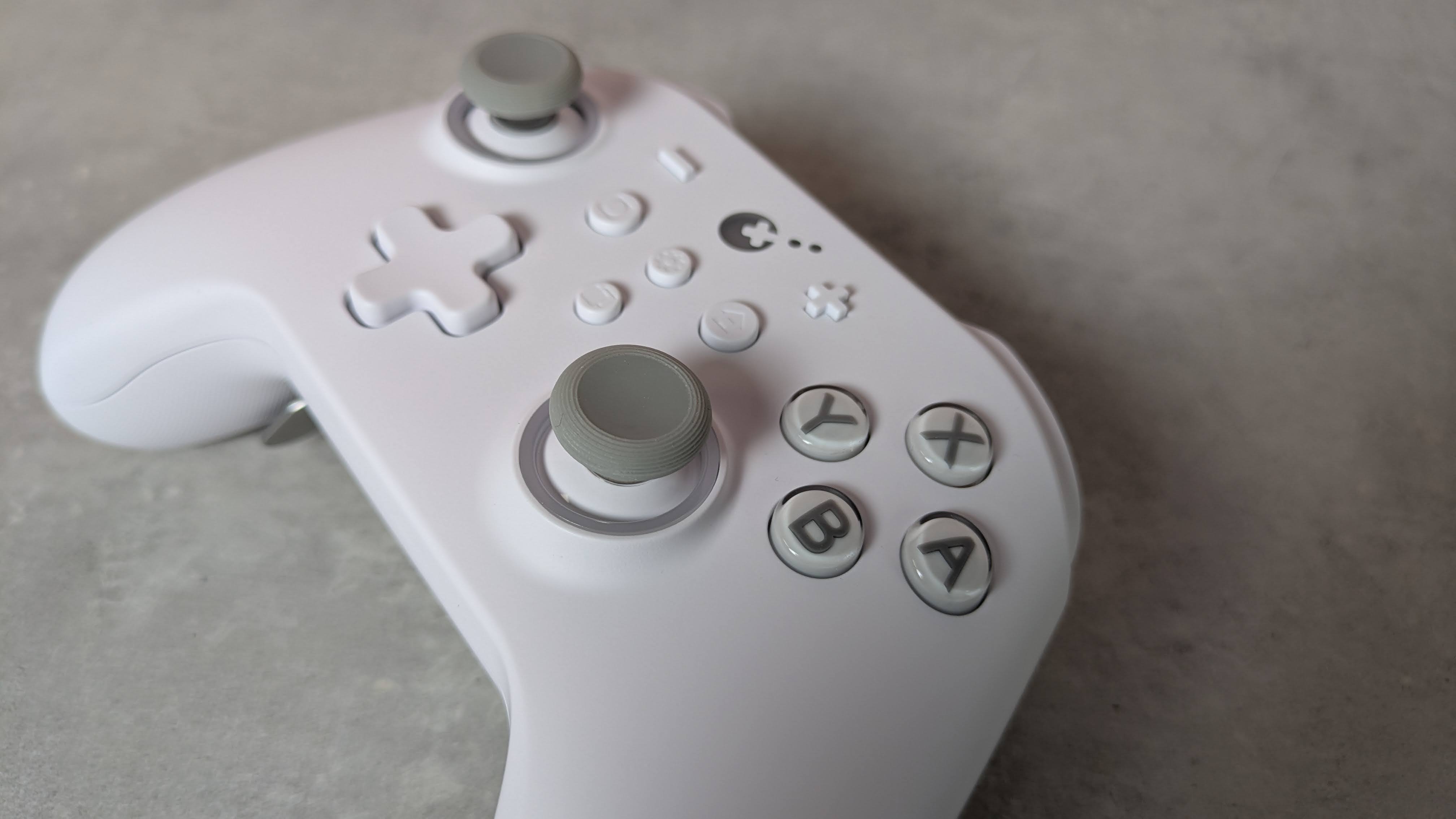 Close-up of right analog stick on GuliKit KK3 Max, on a grey desk