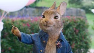 Peter Rabbit 2 movie still of Peter wearing a blue jacket and holding up a gold ring. 