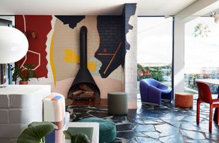 a colorful open plan living room with a wall mural