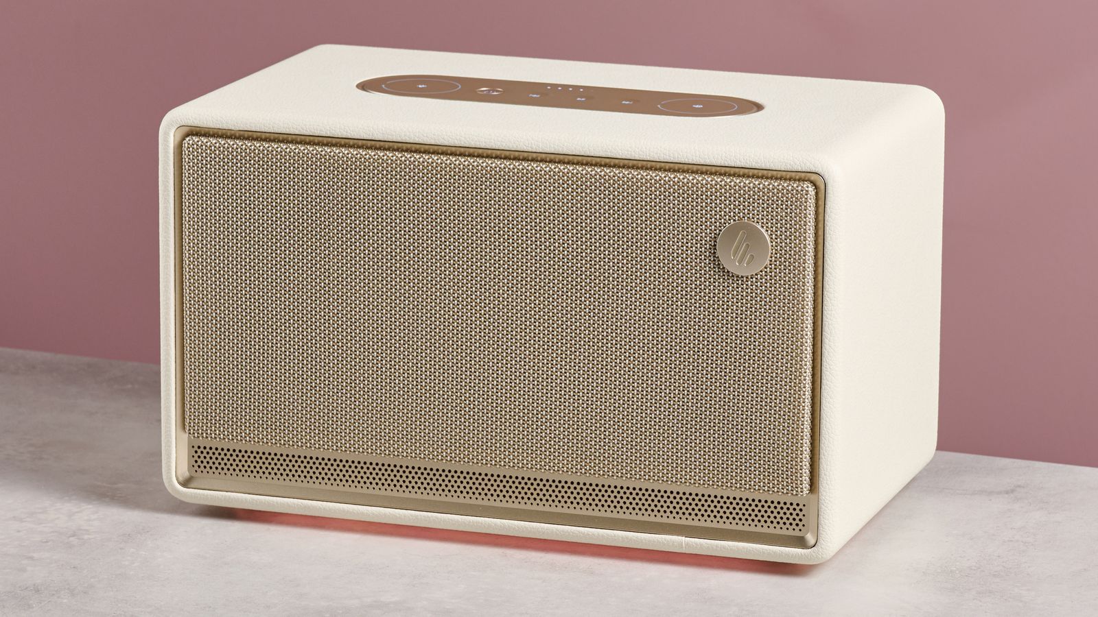 The Edifier ES300 with a glowing amber light beneath, in front of a pink background.