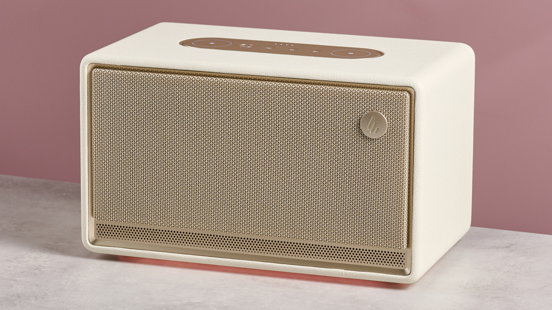 The Edifier ES300 with a glowing amber light beneath, in front of a pink background.