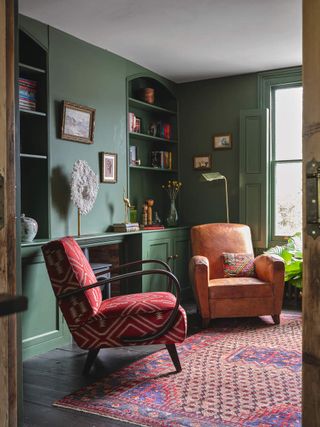 A green painted living room with a red printed sofa