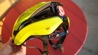 Lumos Ultra Fly Pro bike helmet in neon yellow against a red background