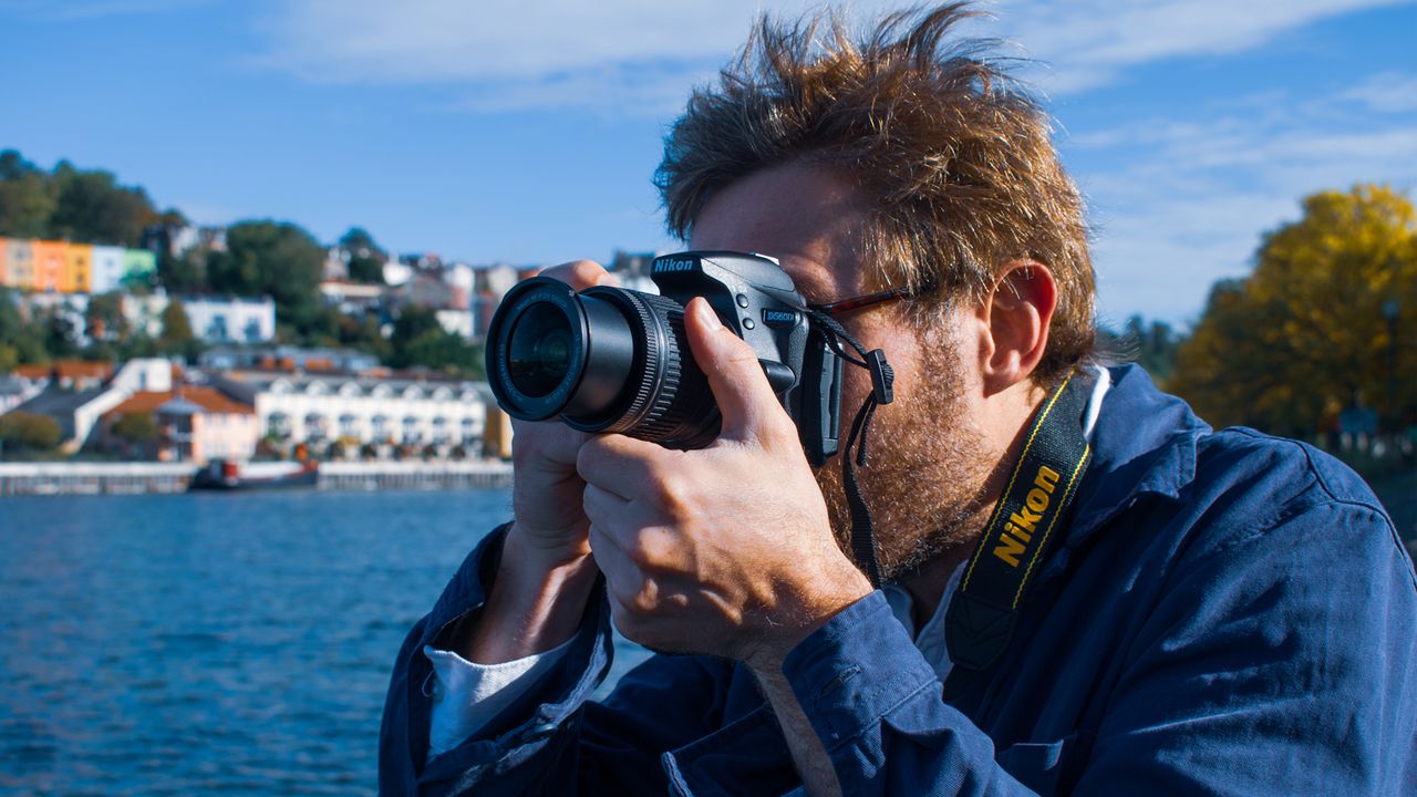 Nikon D5600 review: images shows photographer using Nikon D5600 camera