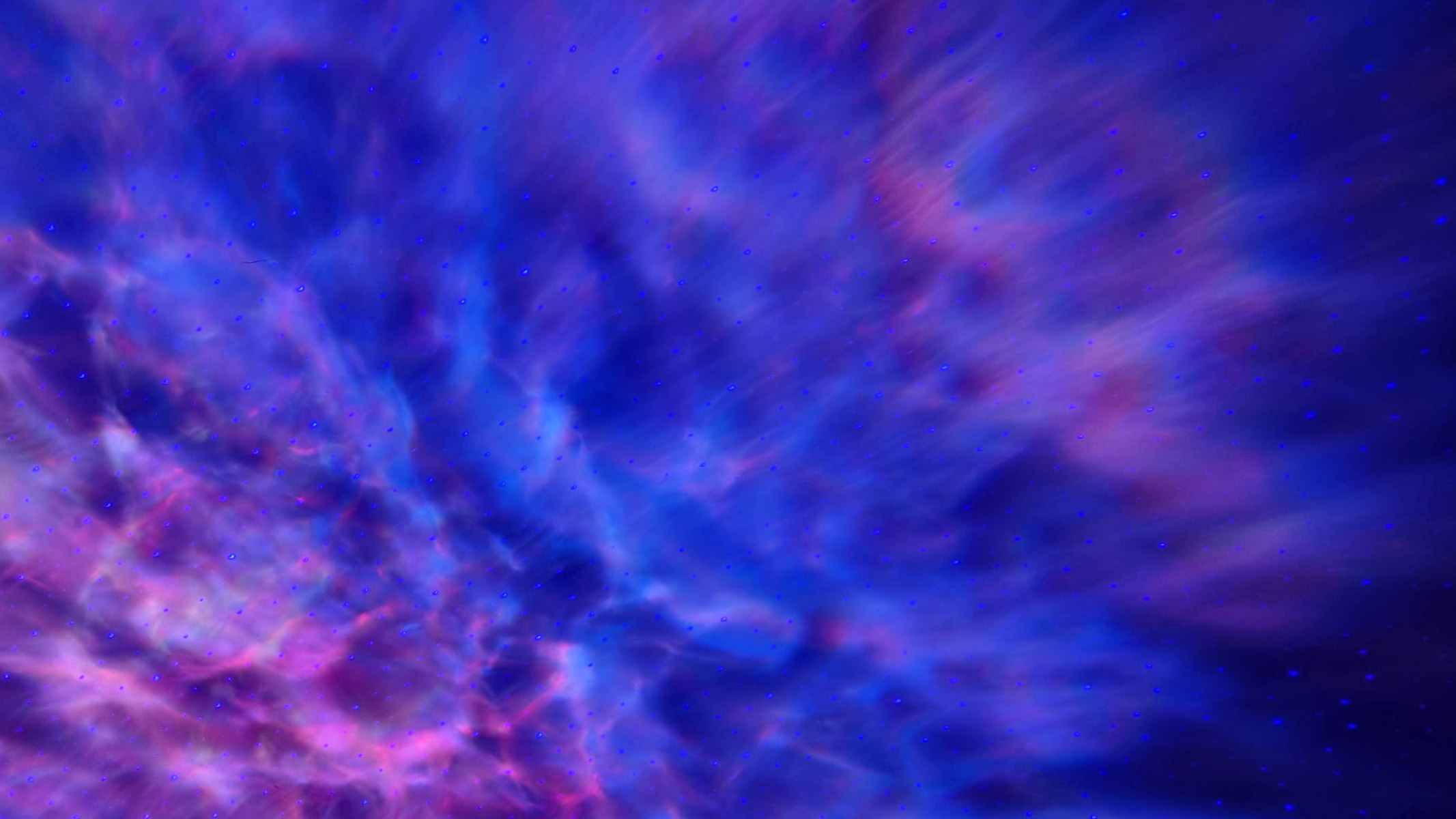 A photo of a nebula projection featuring deep blues, purples, pinks and white.