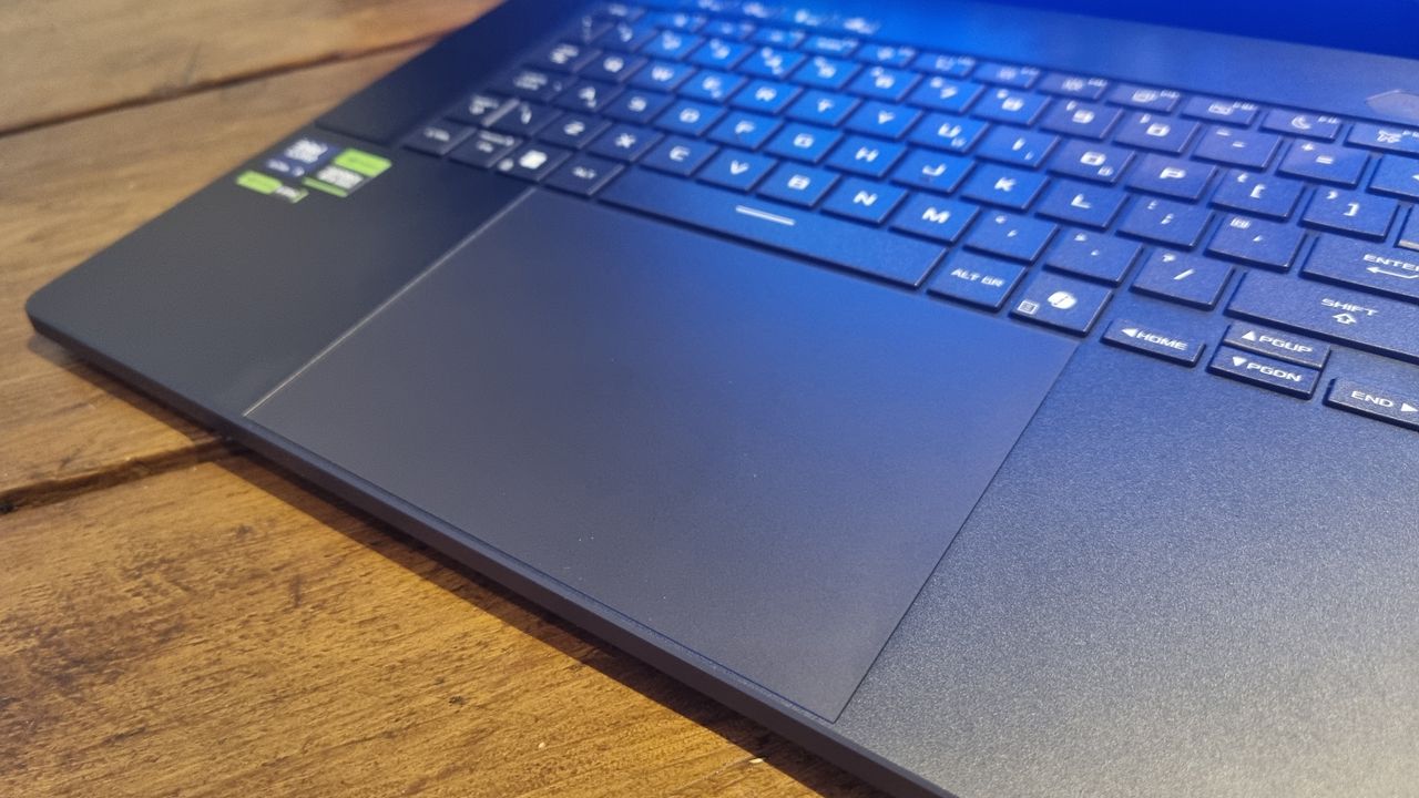 The trackpad and keyboard of the Asus ROG Zephyrus G16 2025, with the keeb lit up in RGB colours