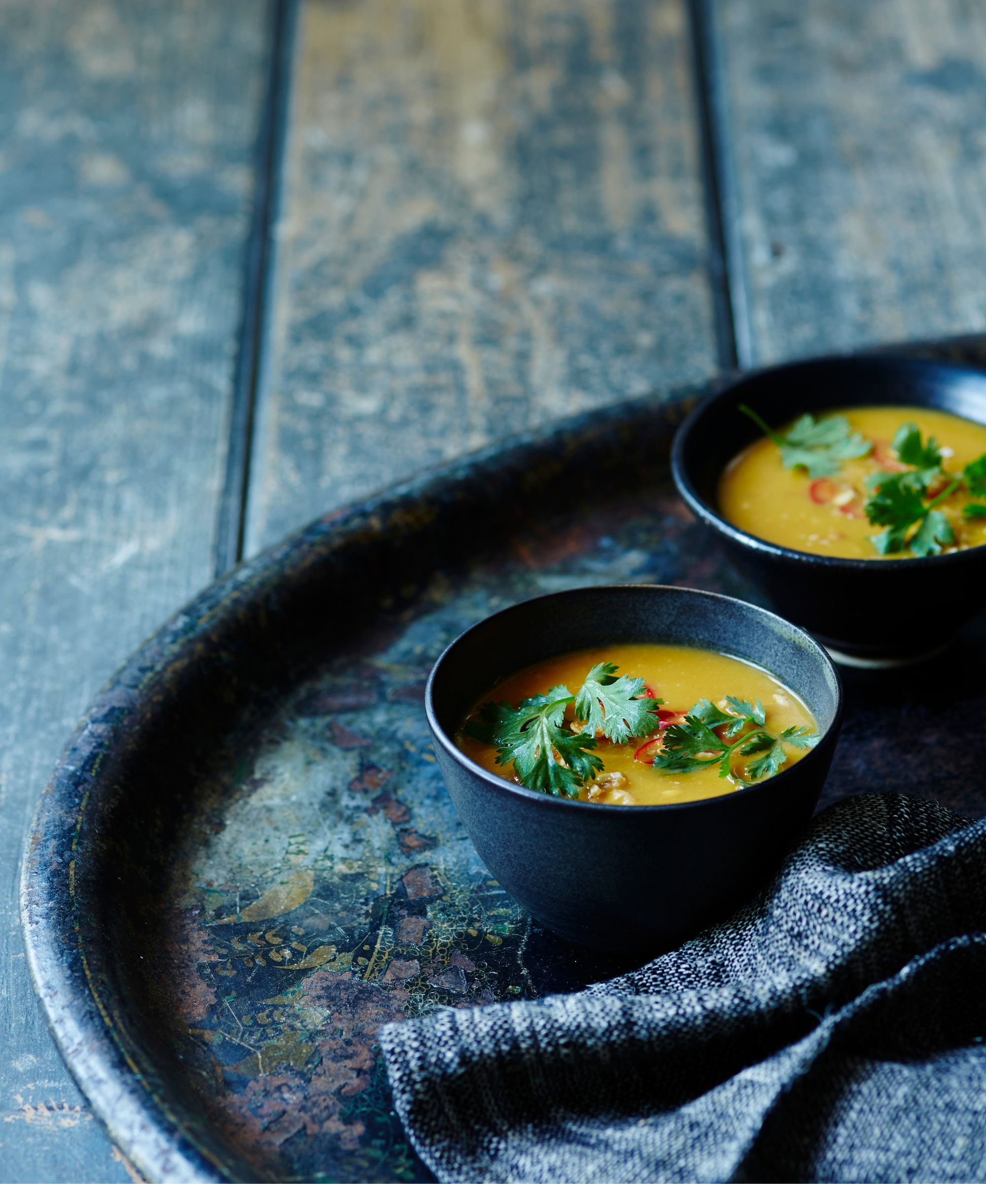 Bowls of Thai soup on a black tray