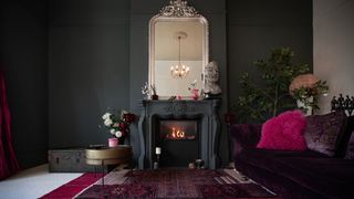 Living room fireplace painted in black with soft furnishings in burgundy