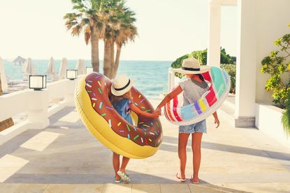Two children with inflatable toys on the beach