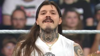 Dirty Dom smirking at the camera after kicking a wrestler. 