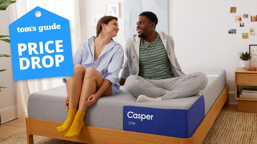 A couple sit on the Casper The One mattress in a bedroom, a Tom&#039;s Guide price drop deals graphic (left)