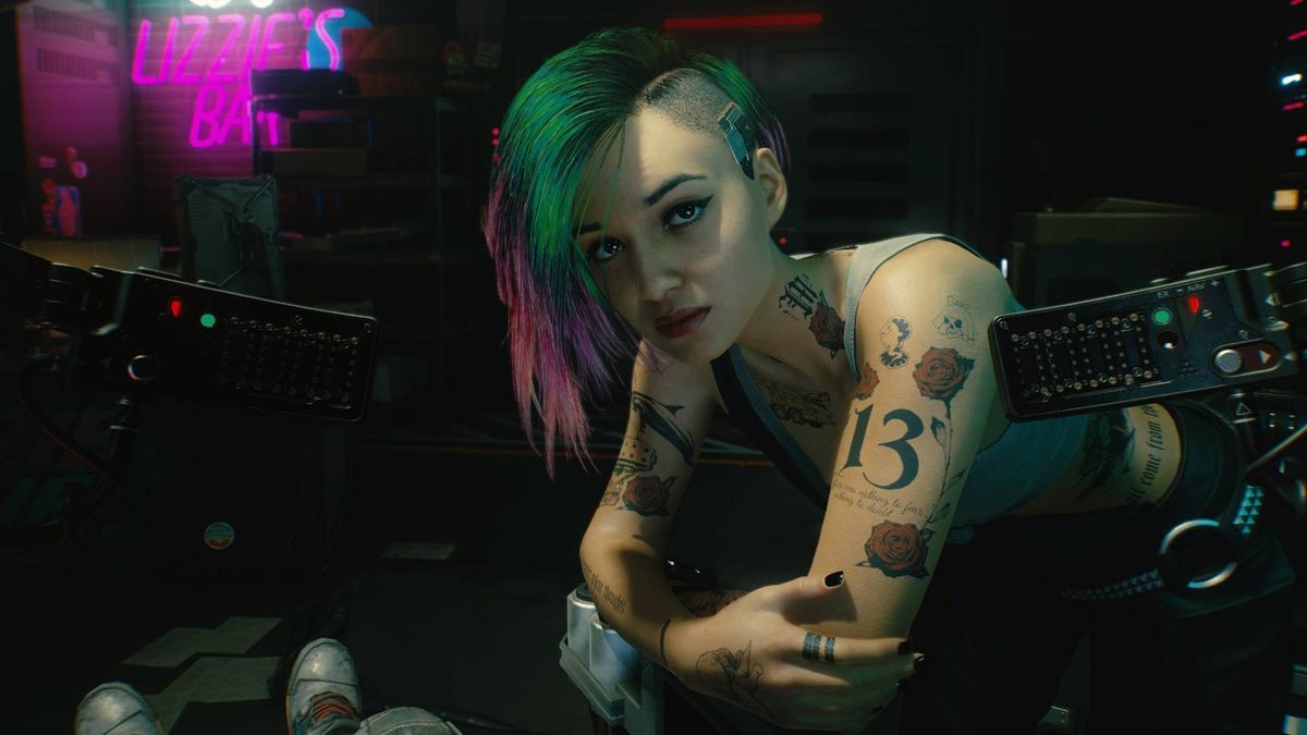 Judy in Cyberpunk 2077 leaning over the player in a chair.