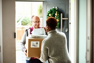 woman receiving parcels from a delivery man at home