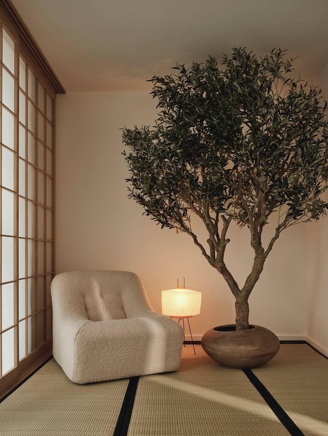 Room with boucl&amp;eacute; chair, cozy lamp and indoor tree