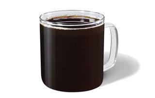 A glass mug filled to the top with Starbucks black Filter Coffee