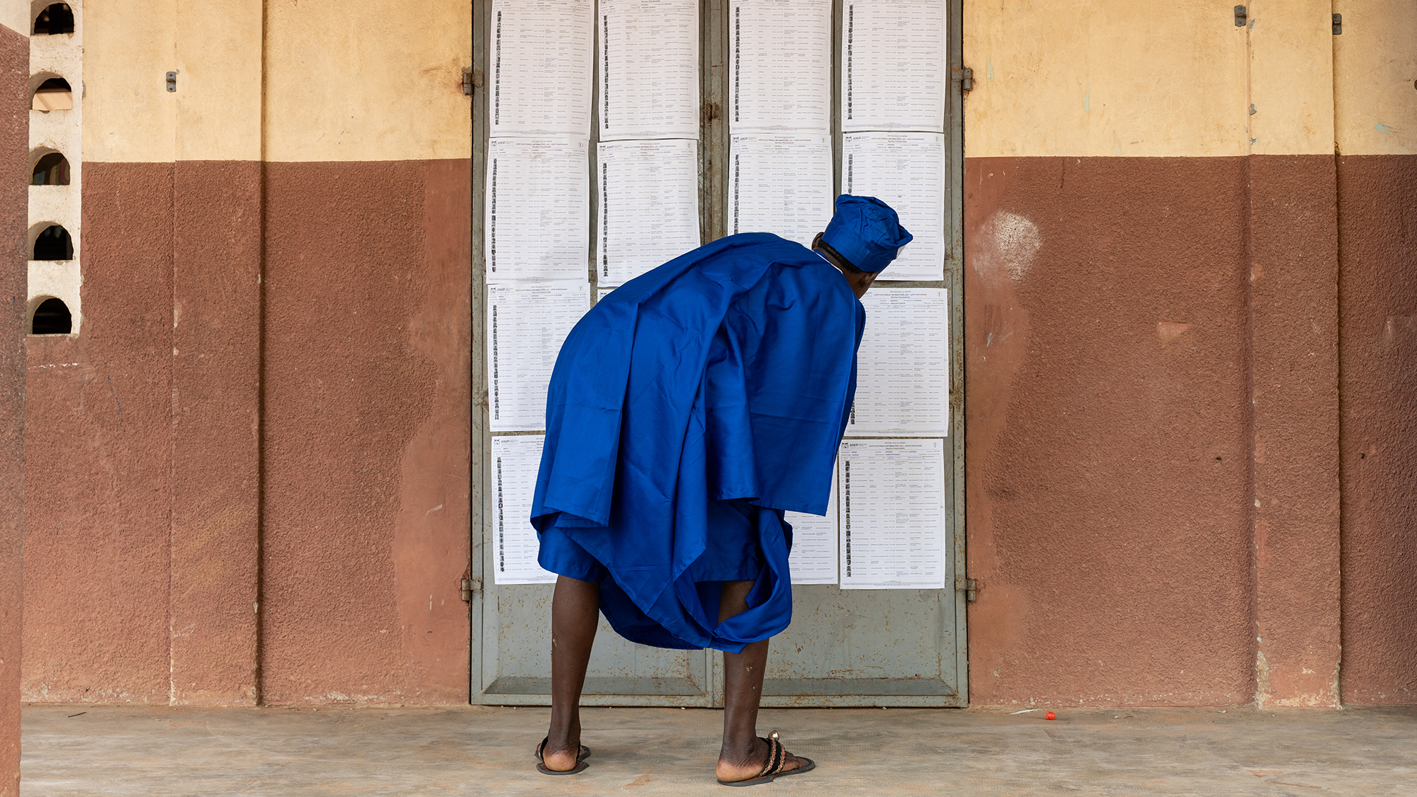 A man inspects the voter rolls at a polling station during the presidential election in Lokossa, Benin