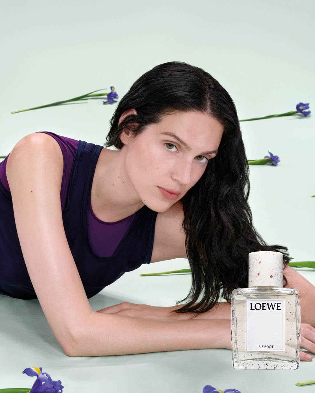 eva victor laying on the ground with the loewe iris root perfume
