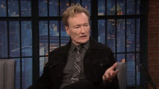 Conan O'Brien speaking with Seth Meyers on Late Night