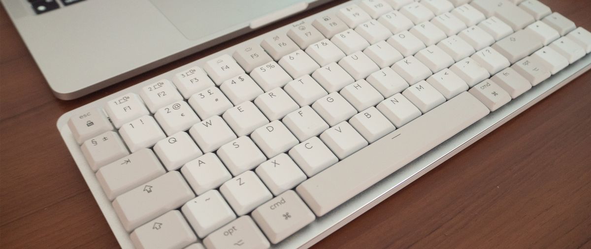 A white Logitech MX Keys Mini for Mac keyboard sitting on a desk