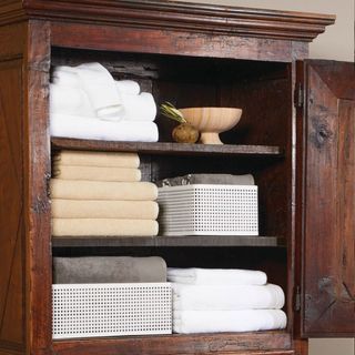 A wooden hutch with stacks of folded bath towels