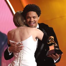 Taylor Swift receives a Grammy Award from host Trevor Noah at the 2024 ceremony