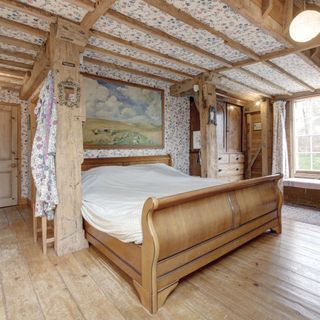 watermill bedroom with wooden beams and flooring
