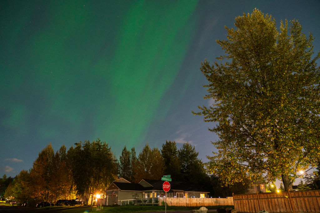 Cahaya utara di atas Alaska. Tirai cahaya hijau memenuhi langit.