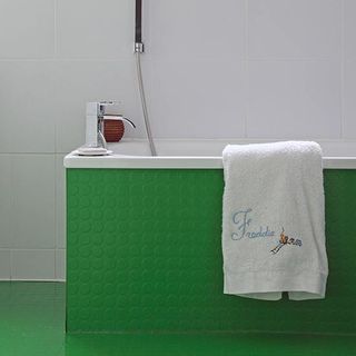 bathroom with green bathtub and towel