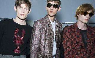 Two male models wearing clothing by Dries Van Noten in various colours.