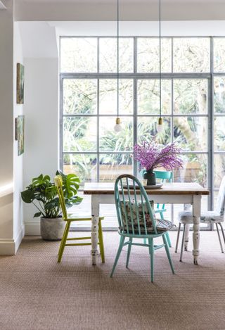Natural flooring in a dining area with colourful dining chairs