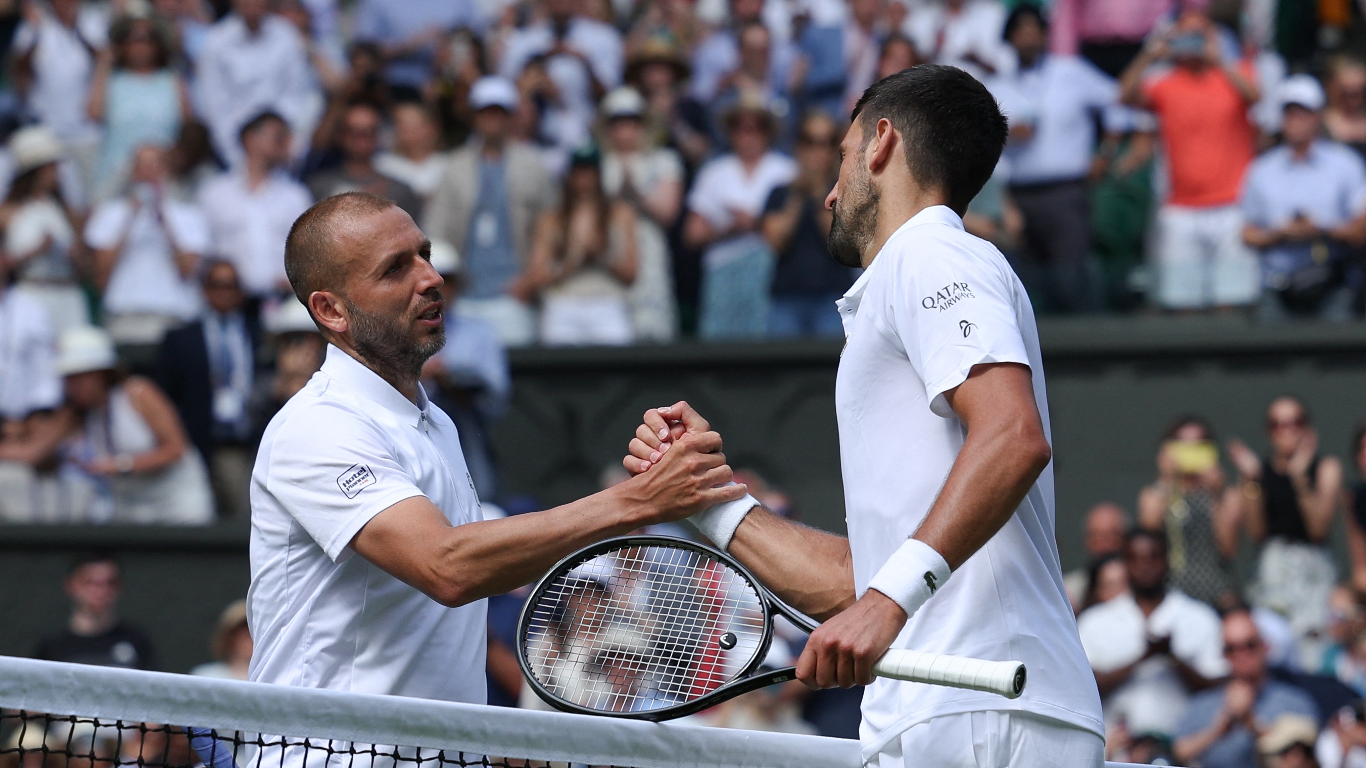 Novak Djokovic shakes hands with Dan Evans after beating him 3-0 in the second round of Wimbledon 2025.
