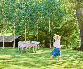 lawn with small skipping girl and trees