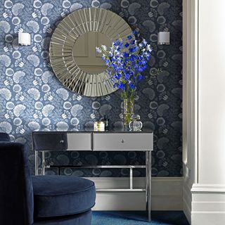 room with wallpaper on wall and designer mirror