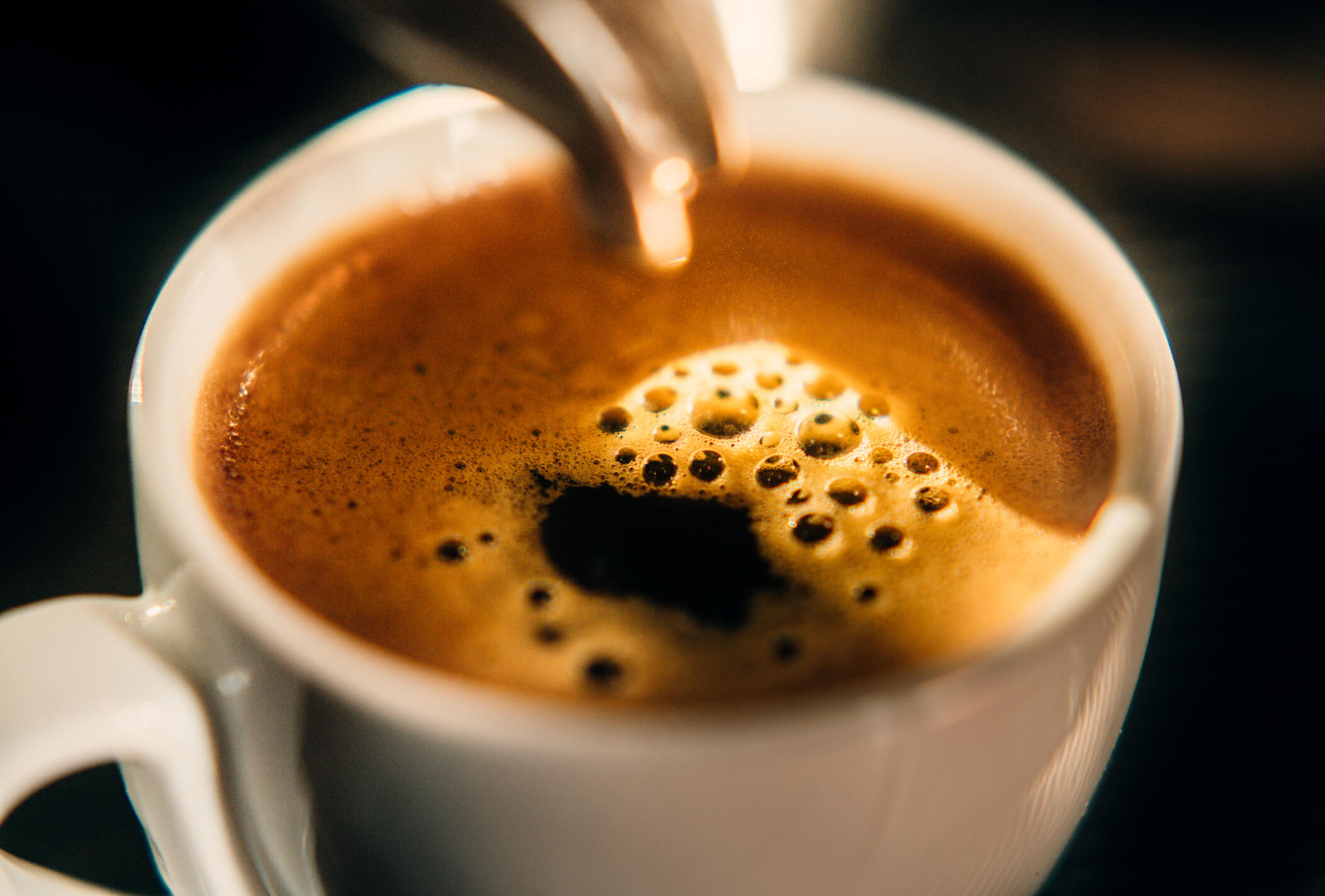 A close-up of a coffee in a small, white mug.