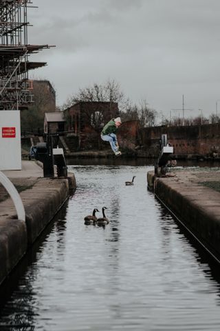 A man jumping over a canal in Manchester