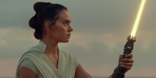 Rey with her lightsaber on Tatooine