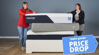 Two mattress testers stand either side of a stack of memory foam mattresses, including the Nectar Classic and Siena, on a bed frame. A Tom's Guide Price Drop deals graphic in the bottom right corner