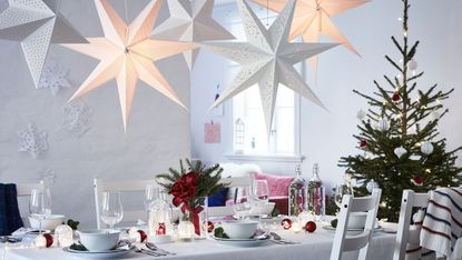 Ikea Christmas dining table decorated for Christmas with a Scandi theme and LED star lights overhead