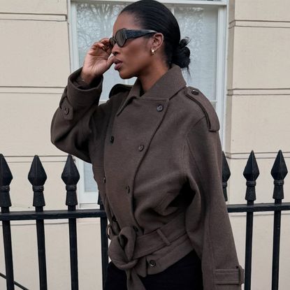 Marilyn wears a brown coat with black sunglasses.