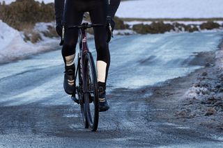 Snowy lane with a cyclist wearing Lake 146 boots