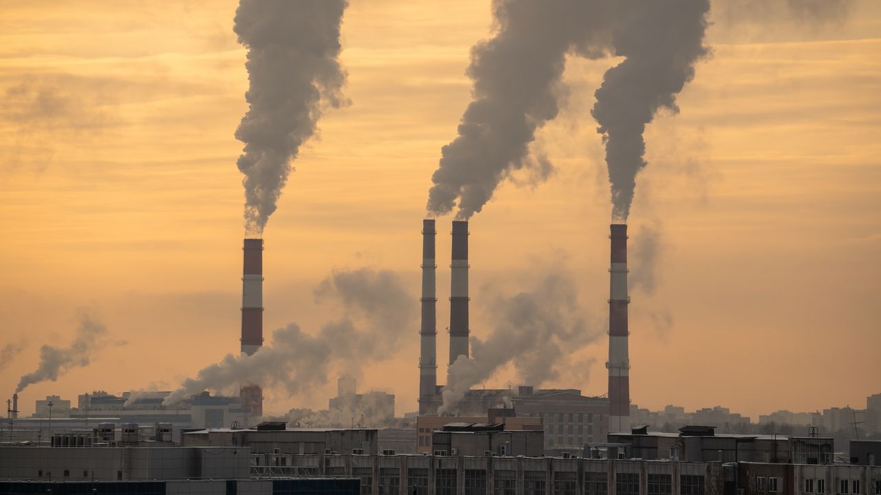 an image of smokestacks at sunset